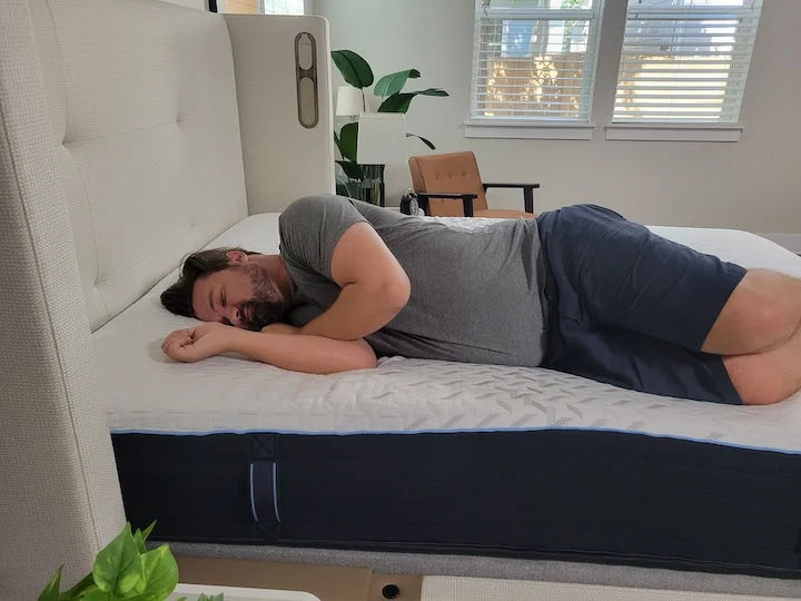 A man sleeps on his side on the Nectar Classic Hybrid.