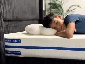 A young boy sleeping on the Nectar Kids mattress