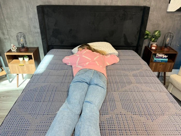 A tester rests on her stomach on the Copperflex mattress