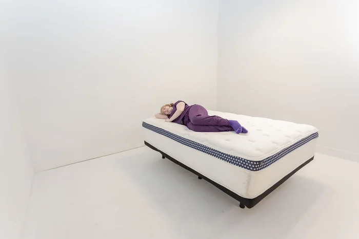 Tester side sleeping on the Winkbed Plus