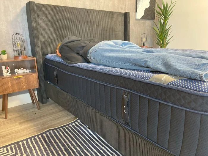 Our tester laying on her stomach on the DreamCloud Luxe Memory Foam mattress