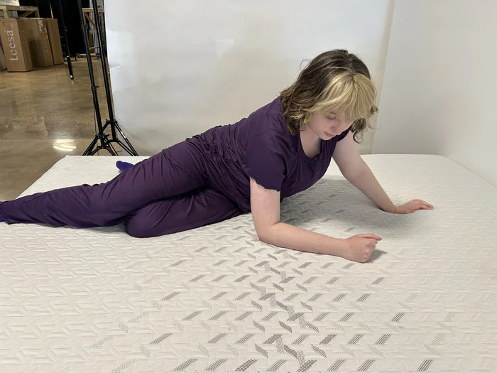 A woman pushes herself up to change sleeping positions on the Nectar Classic mattress