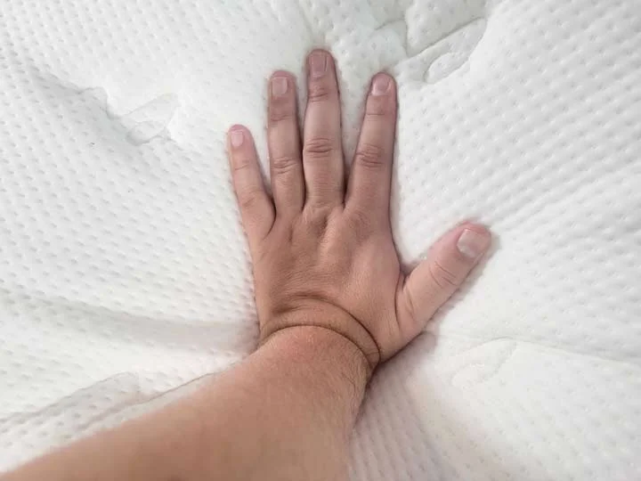 An image of a man's hand pressing into the top of the Titan Plus Luxe