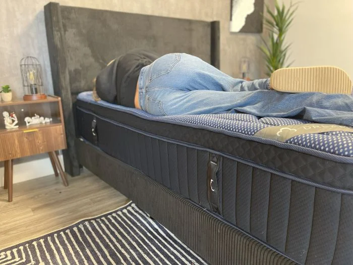 Our tester laying on her side on the DreamCloud Luxe Memory Foam mattress