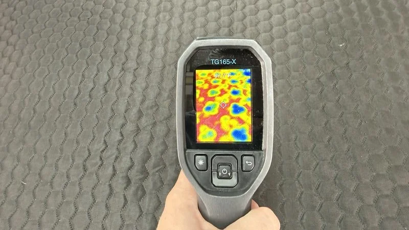 A heat gun is aimed at the surface of the Chilipad 2.0 to display how the water begins to cool the surface