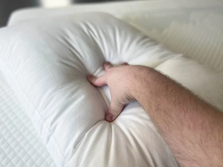 Purple Cloud Pillow firmness A hand presses into the Purple Cloud Pillow to show its firmness