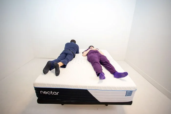 A man and a women testing couples motion isolation on the Nectar Classic Hybrid mattress.
