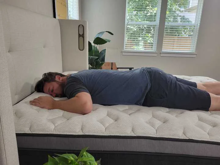 a man sleeps on his stomach on the Helix Plus Luxe