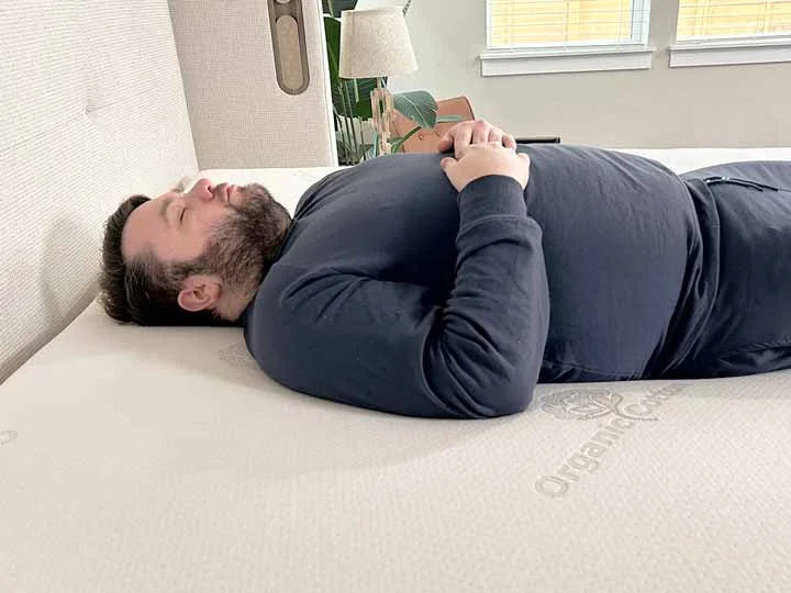 An image of a man resting on his back while on top of the Brooklyn Bedding Latex Topper