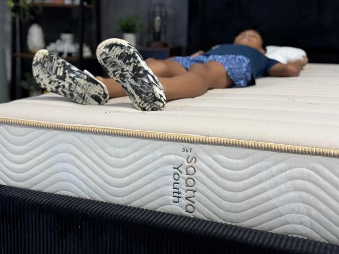 Our tester back-sleeping on a Saatva Youth Mattress