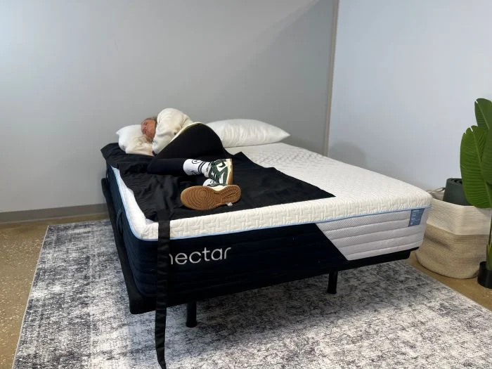 A woman lays on her side on the Nectar Classic Hybrid mattress.