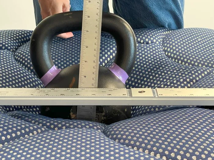 A kettlebell is used to measure sinkage on the DreamCloud Luxe Memory Foam mattress