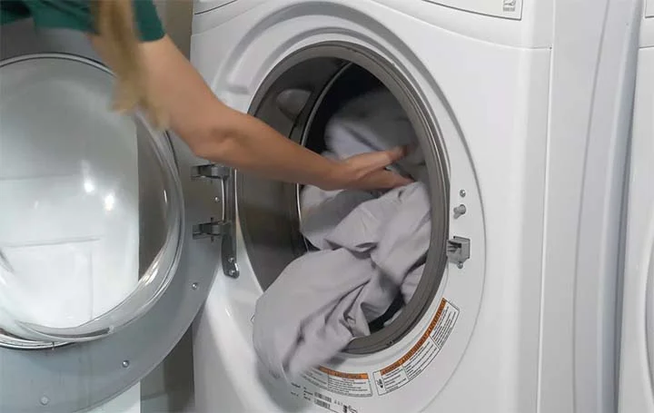The Best Egyptian Cotton Sheets - An image of a woman putting in the Parachute sheets into the washing machine. The Best Egyptian Cotton Sheets - An image of a woman putting in the Parachute sheets into the washing machine.
