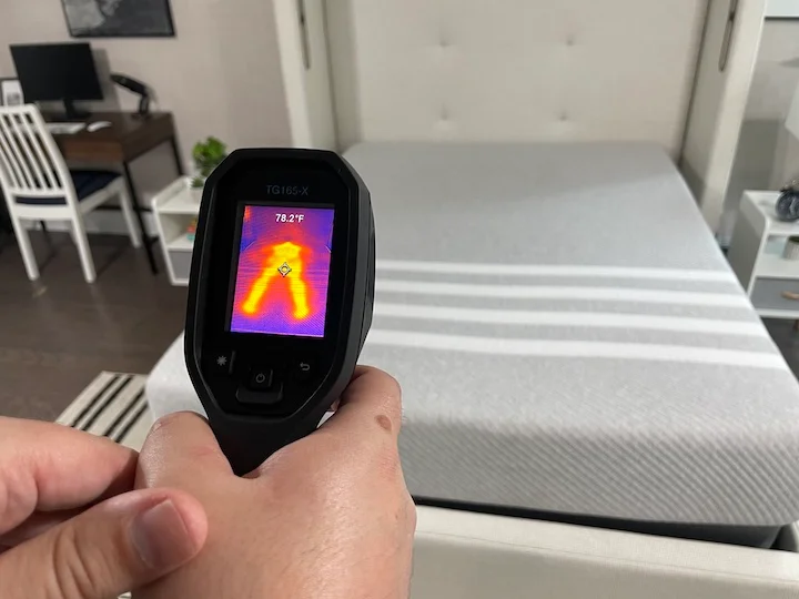 a tests the heat retention of the Leesa Original Mattress with a heat gun