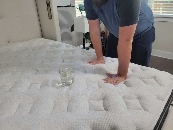 a man tests the motion isolation of the Helix Plus Luxe