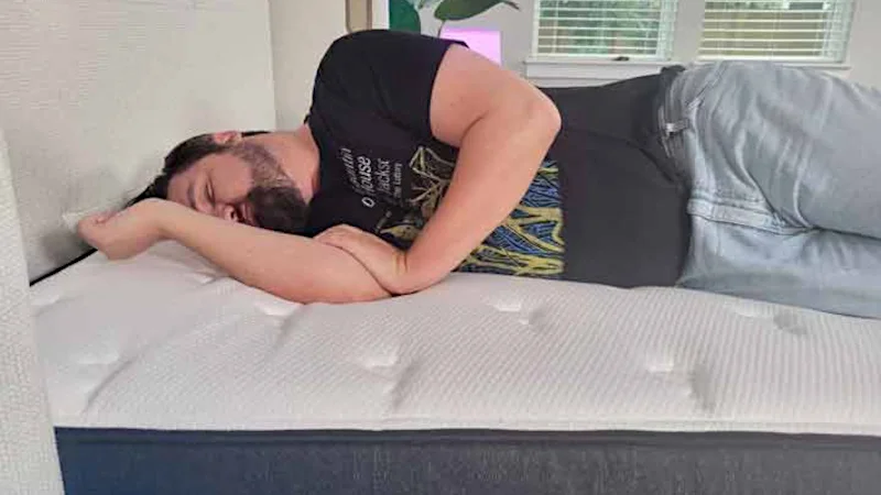 A person sleeps on their side on the Titan Plus Luxe mattress