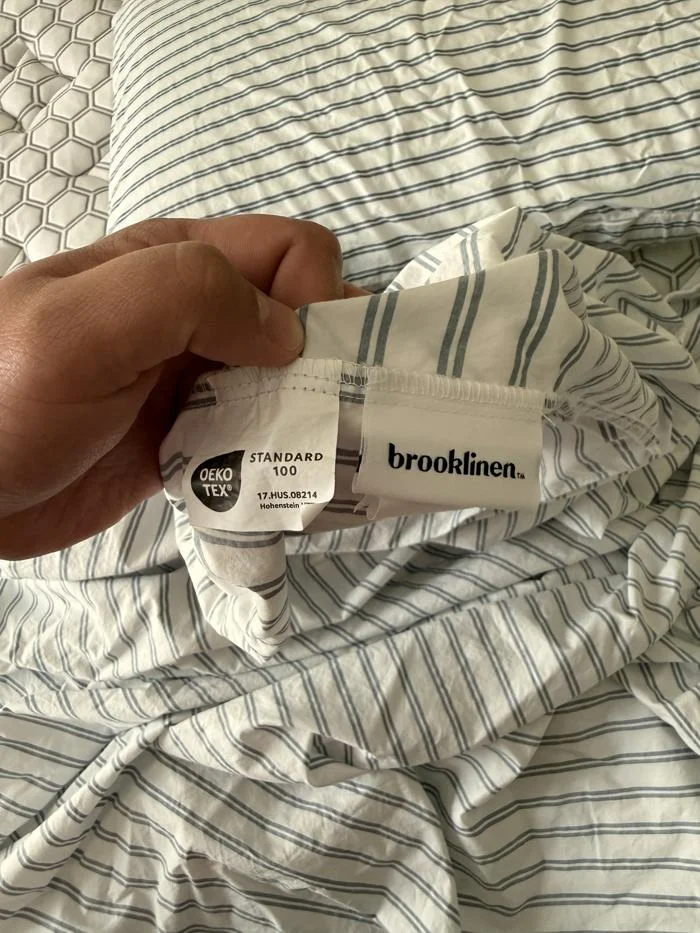 Tags and certifications on the Brooklinen Classic Percale Sheet Set