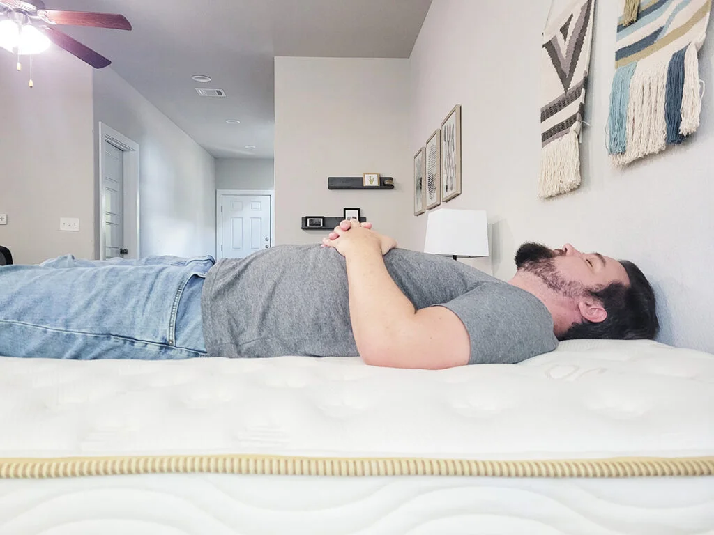 A man sleeping on his back on the Saatva mattress