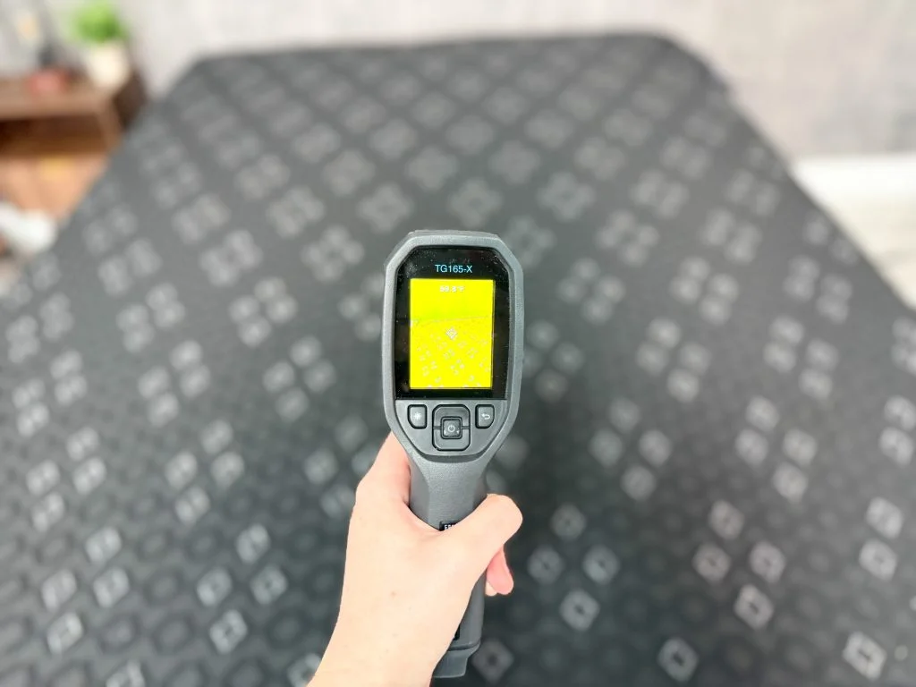 Using a thermal gun on the surface of the Beautyrest Black Hybrid XCS to determine the initial temperature for our cooling test