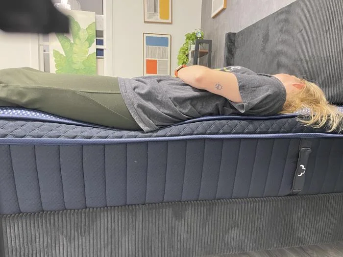 Our tester does a back-sleeping full body edge support test on the DreamCloud Luxe Hybrid
