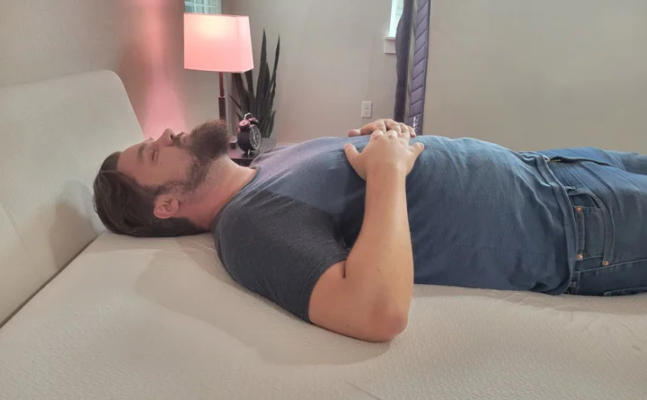 A man sleeps on his back on the Polysleep Origin