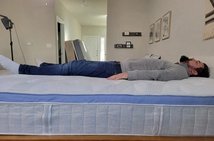 A man sleeps on his back on the Bear Star Hybrid