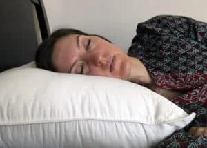 A woman rests her head on the Brooklinen Down Alternative Pillow. A woman rests her head on the Brooklinen Down Alternative Pillow.