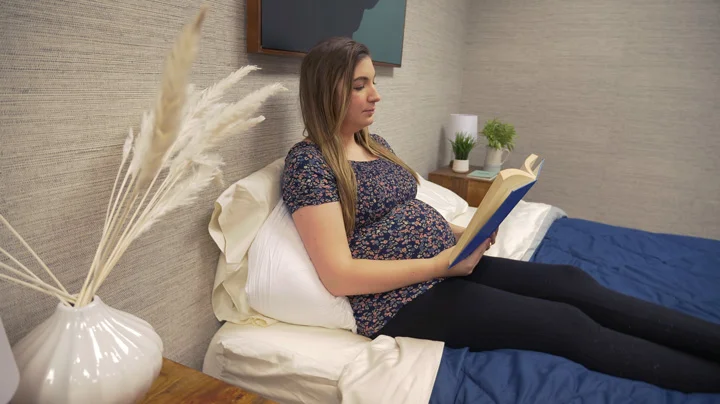 A pregnant woman lounges with the Buffy Wiggle pillow