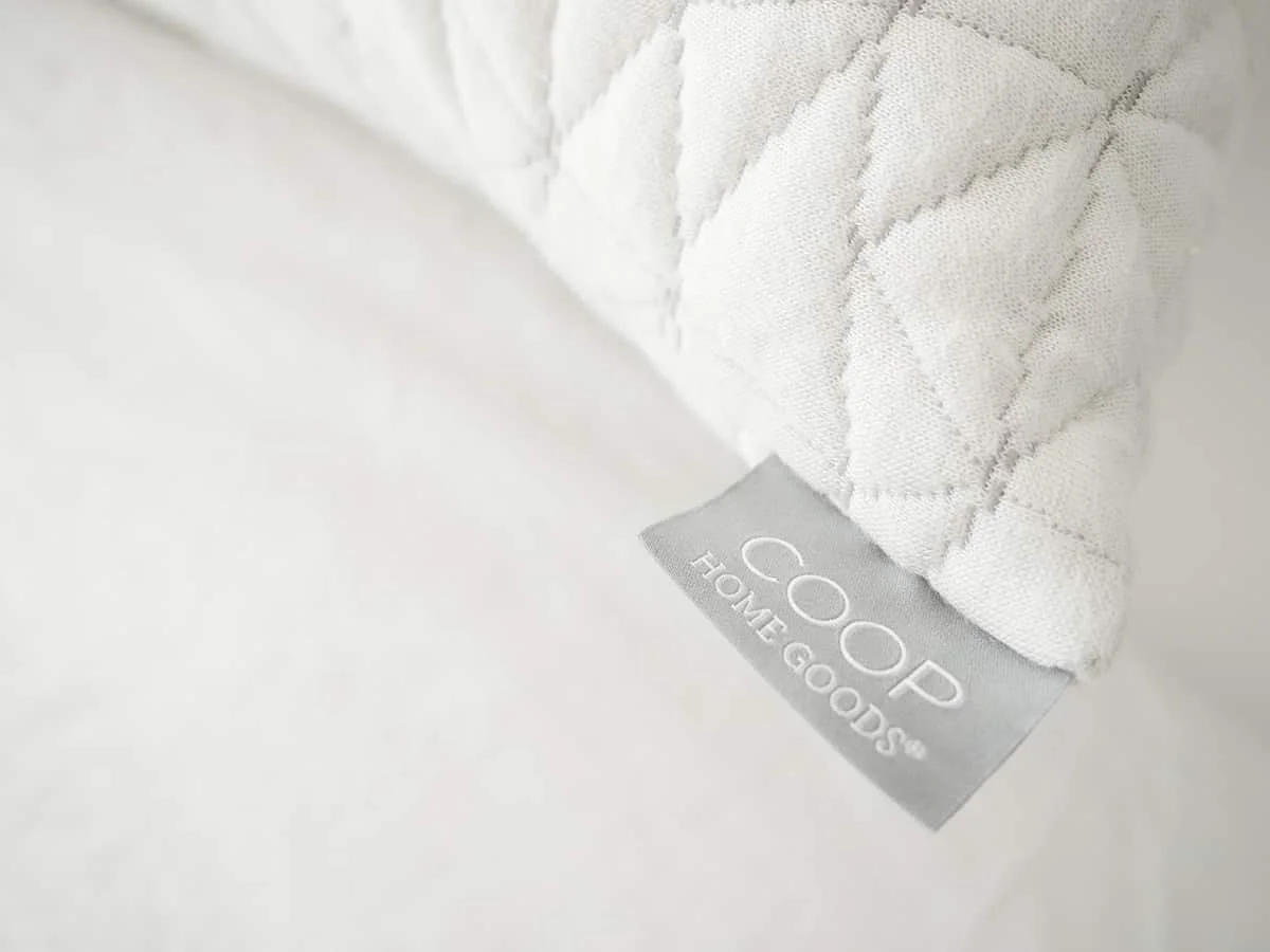 A Coop Home Goods tag displayed on the corner of an Original Pillow