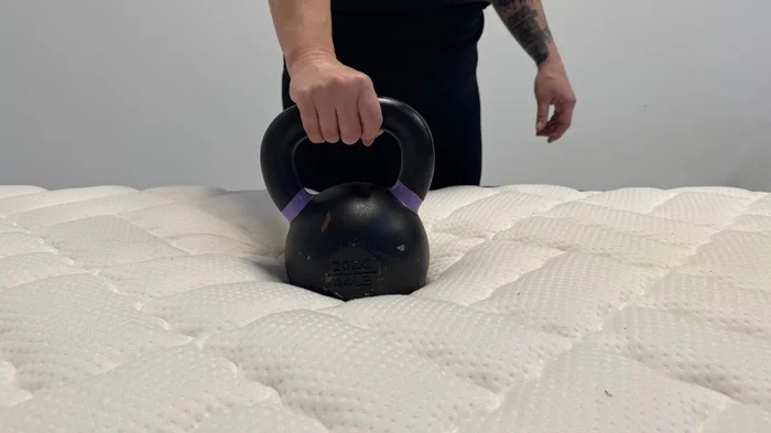 Tester performs the responsiveness test on the Titan Plus mattress
