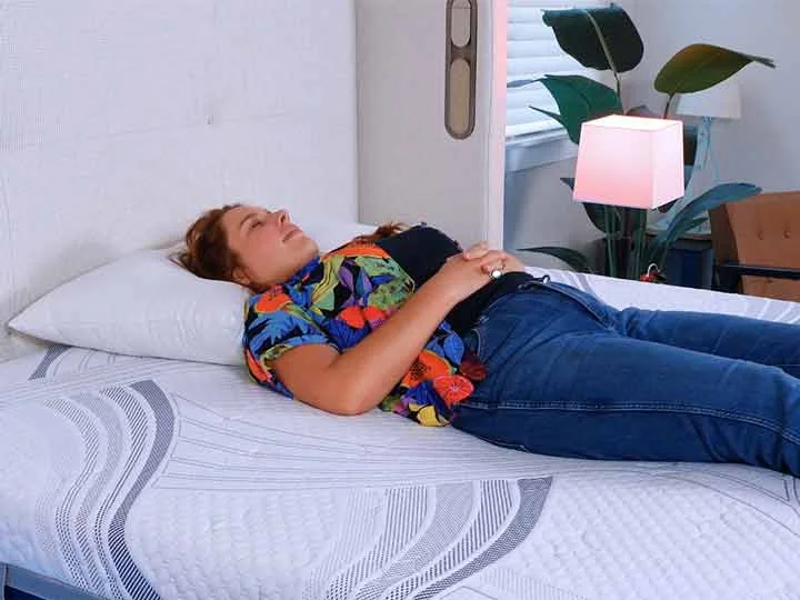 An image of a woman sleeping on her back while on top of the Novaform mattress.