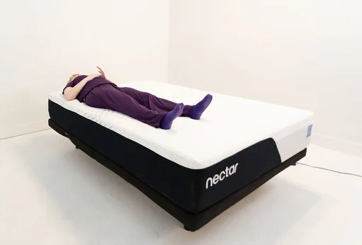 A woman resting on her back on the Nectar Classic mattress