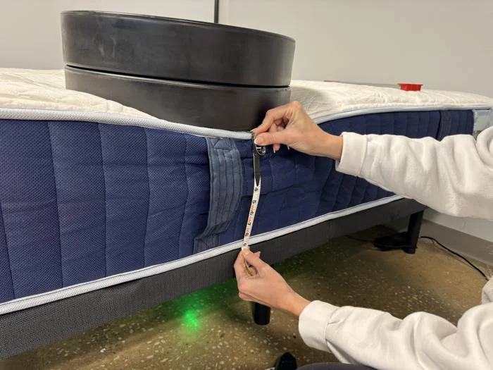 Measuring weight plates on the edge of the Glacier Original Hybrid Mattress