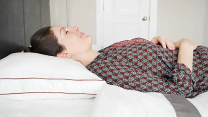 A woman sleeps on her back using the Saavta pillow. A woman sleeps on her back using the Saavta pillow.