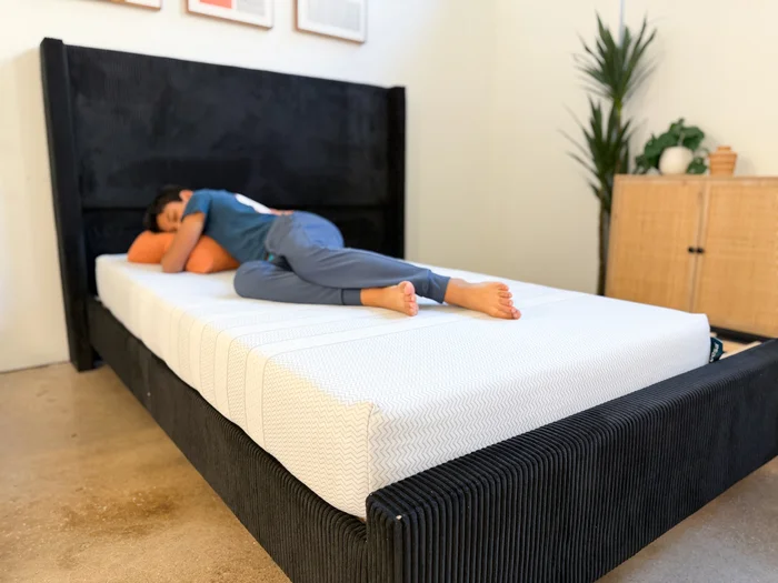 A young tester rests on his side on the Leesa Kids mattress