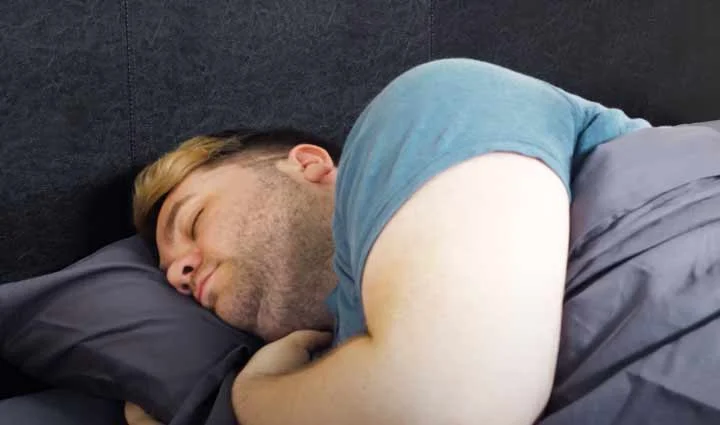 A man sleeps on his side on Brooklinen Luxe Sheets A man sleeps on his side on Brooklinen Luxe Sheets