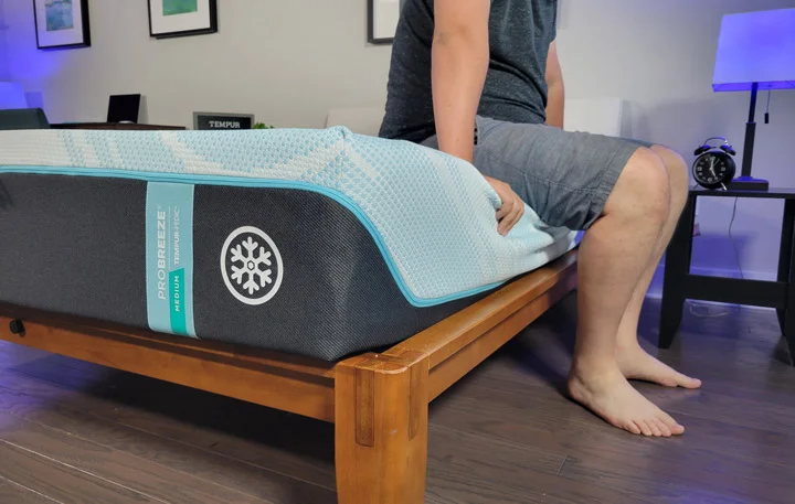 A man sits near the edge of the Tempur-ProBreeze Mattresss