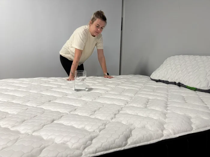 Testing motion isolation on the Titan Plus Core mattress with a glass of water