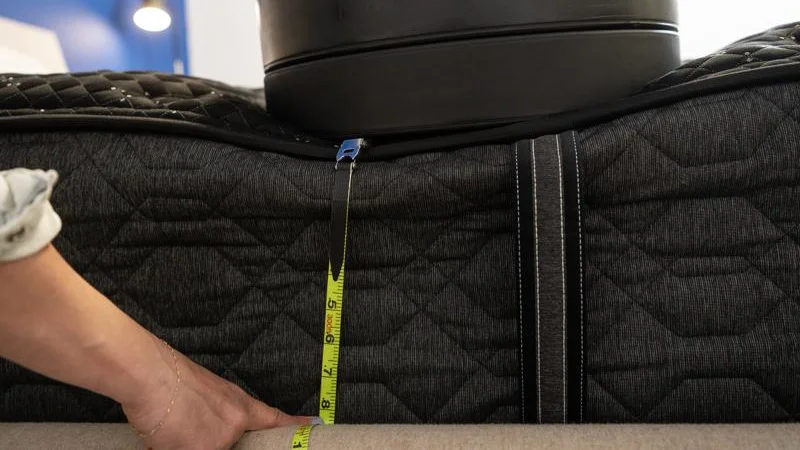 Our tester measures the sinkage from weight plates along the edge of the Beautyrest Black Mattress