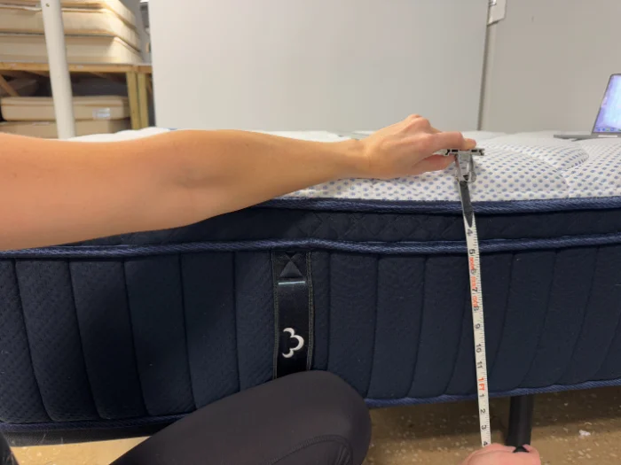 A tape measure showing the 13-inch thickness of the DreamCloud Premier mattress