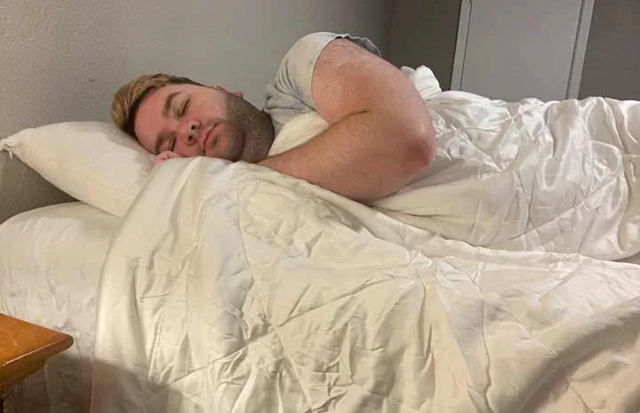 Cozy Earth Comforter - A man sleeps on his side with the comforter.