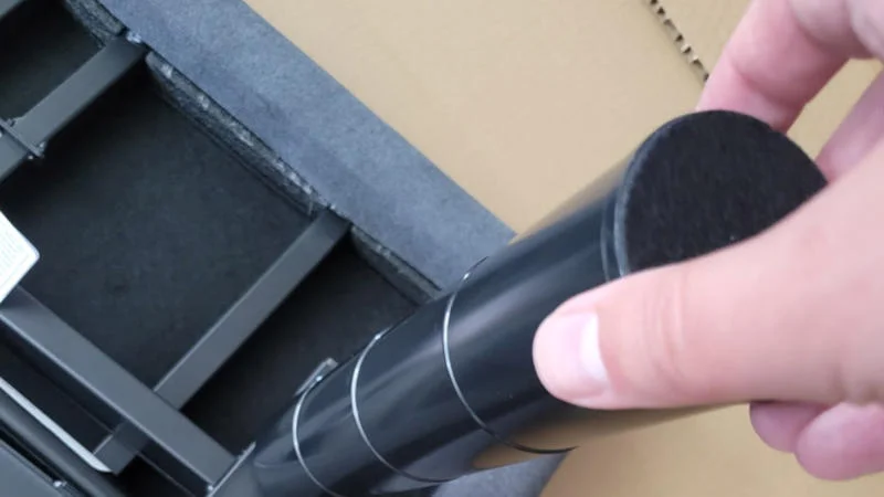 A hand screws a leg into the bottom of the Helix adjustable base