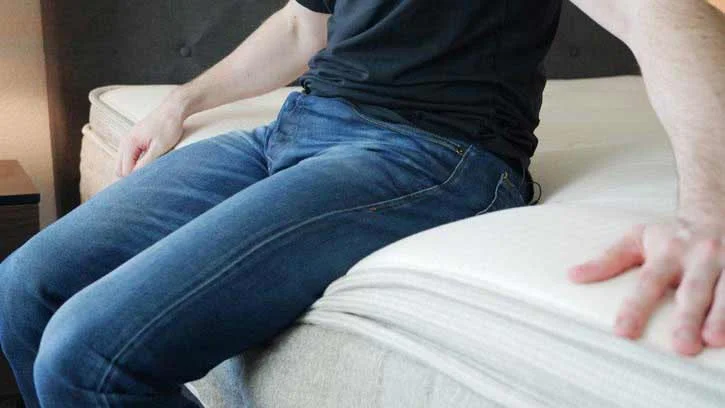 A man sits on his bed. A man sits on his bed.