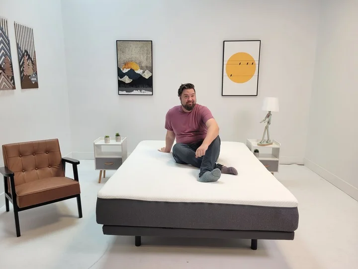 A man sits on top of the Emma Original mattress