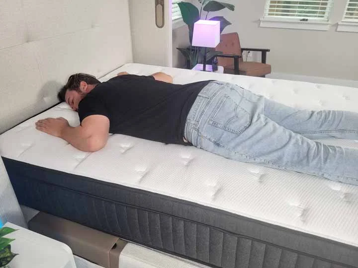 An image of a man sleeping on his stomach while on top of the Titan Plus Luxe mattress
