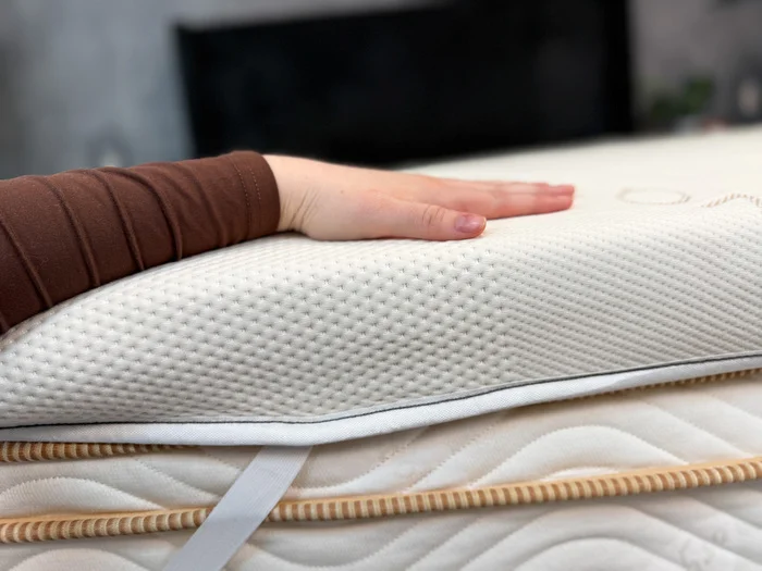 Hand on top of the Saatva Graphite Memory Foam topper