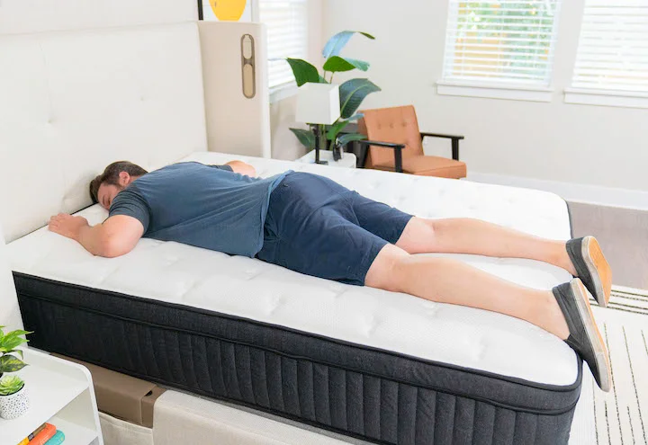 a man sleeps on his stomach on the Titan Plus mattress
