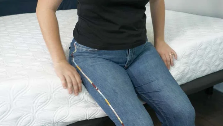 Cocoon Chill - Edge Support woman sitting on the edge of the Cocoon Chill mattress