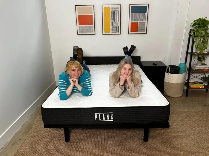Authors Livvi DiCicco and Riley Otis on the Plank Firm mattress by Brooklyn Bedding.