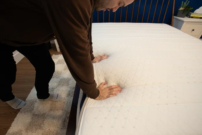 A man pressing into the surface of the Helix Midnight mattress